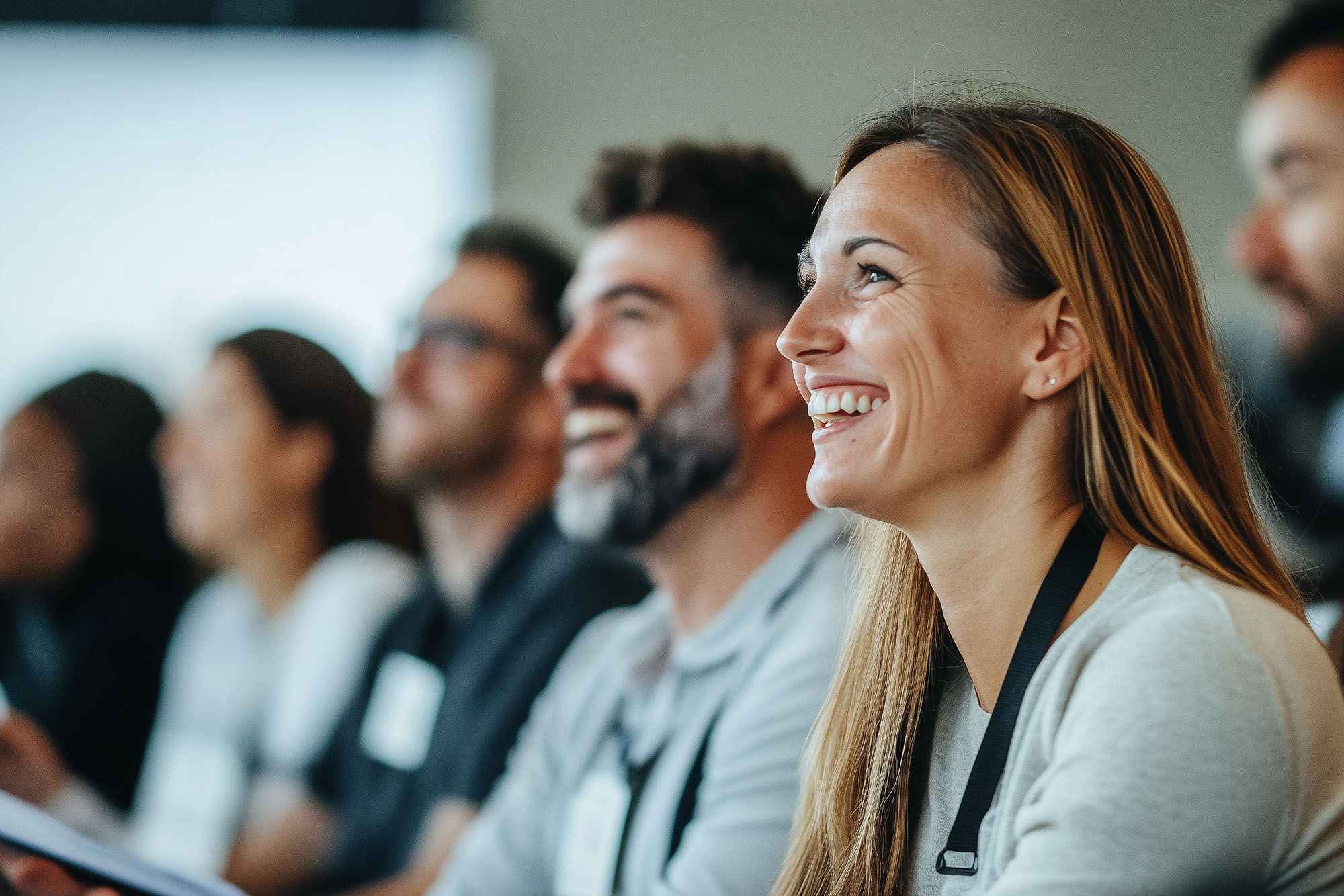 A smiling woman sat with a group of adult learners