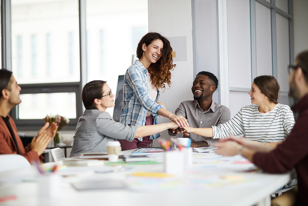 A team of 6 people sat around a desk at a team building event