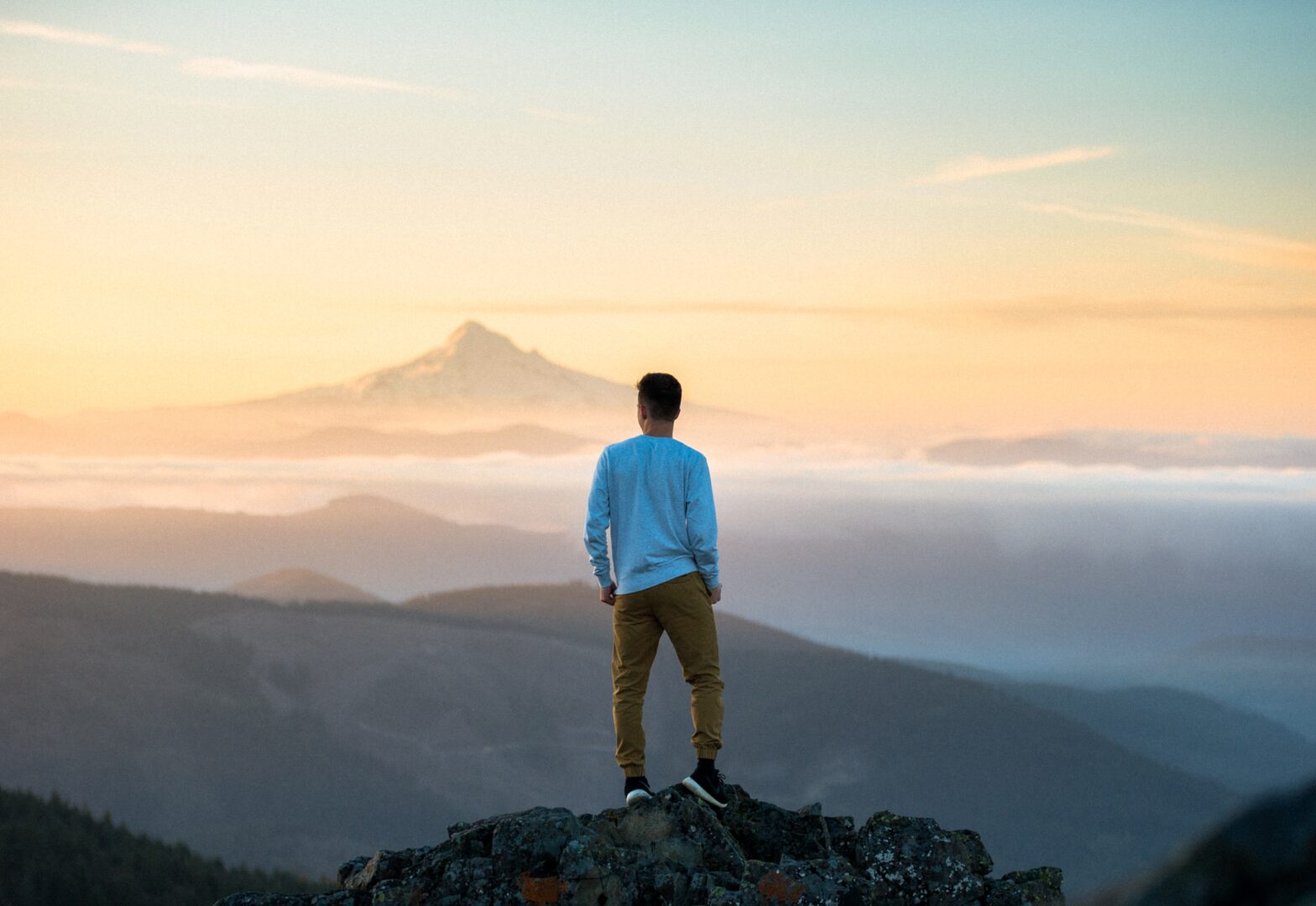Man on mountain top looking at the horizon