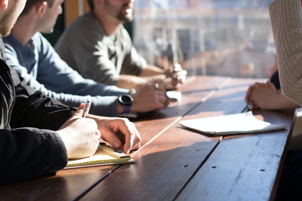 Photo of people demonstrating leadership skills at a desk outside during daytime, by Dylan Gillis on Unsplash