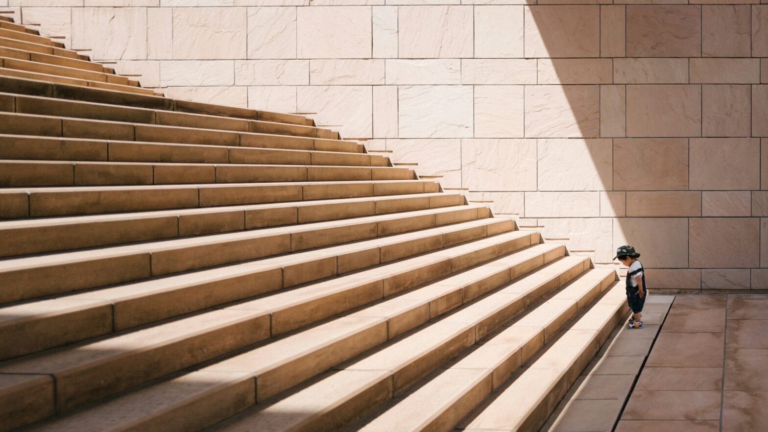 A toddler presented with a challenging set of stairs, similar to the challenge faced by L&D professionals creating a learning strategy for 2024 Photo by Jukan Tateisi on Unsplash